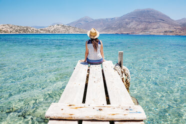 Griechenland, Kykladen-Inseln, Amorgos, Frau sitzt auf dem Rand eines Holzstegs, Insel Nikouria - GEMF01025