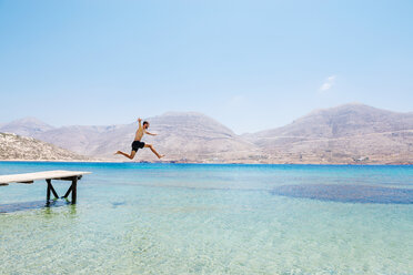 Griechenland, Kykladen-Inseln, Amorgos, Ägäisches Meer, nackter Mann springt von einem Holzsteg - GEMF01030