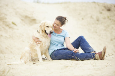 Young woman with dog in sand - MAEF12029