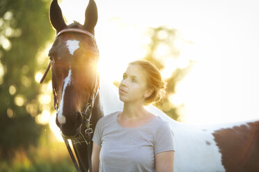 Junge Frau mit Pferd bei Sonnenuntergang - MAEF12041