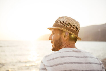 Greece, Cylcades Islands, Amorgos, man enjoying the sunset next to the sea - GEMF01031