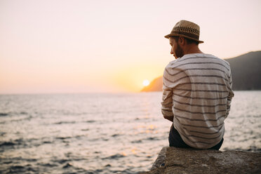 Greece, Cylcades Islands, Amorgos, man sitting at the sea at sunset - GEMF01040