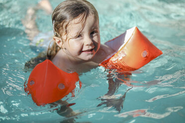 Little girl with floating tire in swimming pool - SHKF00674