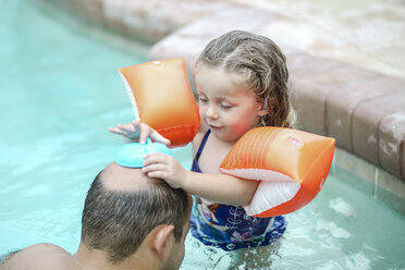 Father and little daughter playing together in swimming pool - SHKF00680