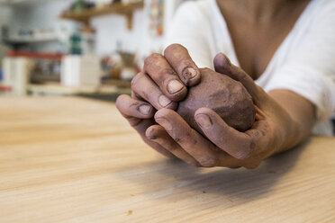 Hands kneading clay in a ceramics workshop - ABZF01260