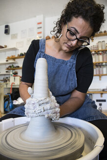 Frau bei der Arbeit mit einer Töpferscheibe in einer Keramikwerkstatt - ABZF01269