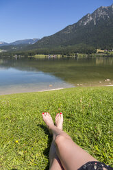 Austria, woman lying on shore of Lake Hallstatt - JUNF00616