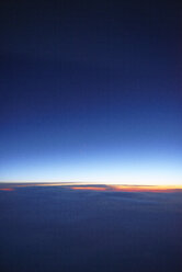 USA, Blick aus dem Flugzeugfenster bei Sonnenuntergang über den Wolken - BRF01411