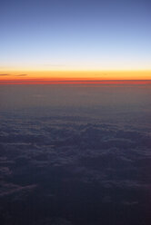 USA, Blick aus dem Flugzeugfenster bei Sonnenuntergang über den Wolken - BRF01412