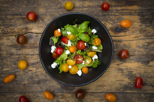 Schüssel mit Blattsalat mit Ziegenfrischkäse und Tomaten auf Holz - LVF05341