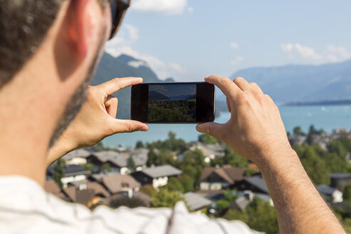 Österreich, Sankt Wolfgang, Mann beim Fotografieren des Wolfgangsees - JUNF00632