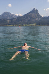 Austria, Sankt Wolfgang, man floating in lake - JUNF00636
