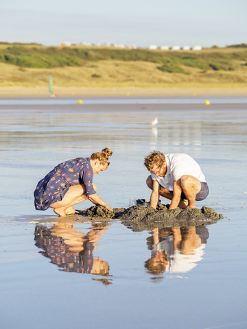 Ehepaar am Strand auf der Suche nach Muscheln, lizenzfreies Stockfoto