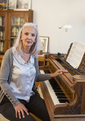 Porträt einer Frau mit Klavier zu Hause - JUNF00679