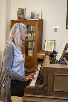 Woman playing piano at home - JUNF00681