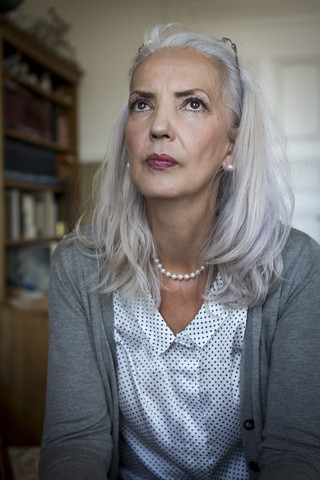 Portrait of pensive woman at home stock photo