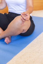 Woman practicing yoga at home, partial view - JUNF00703