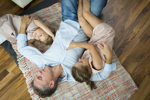 Father cuddling with his daughters at home stock photo