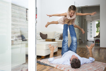 Father balancing his daughter on his feet - JTLF00110