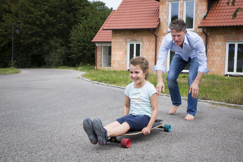 Vater und Tochter beim Longboarden im Garten - JTLF00118