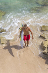 Surfer mit Surfbrett am Strand - KNTF00510