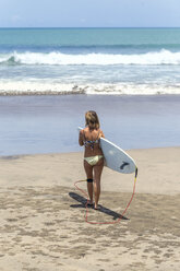 Indonesien, Bali, Surferin am Strand - KNTF00511