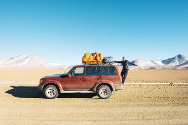 Bolivien, Altiplano, Eduardo Avaroa Andean Fauna National Reserve, Mann hängt an einem 4x4 Auto - GEMF01075