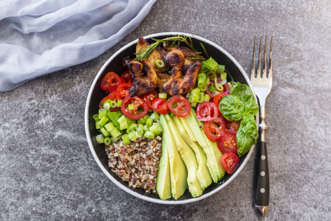 Fried chicken, quinoa, tomato, avocado, spring onion, rosemary and basil in bowl stock photo