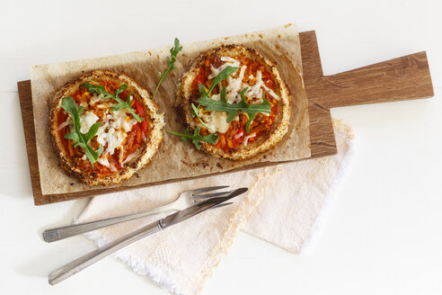 Zwei hausgemachte glutenfreie Mini-Pizzen mit Blumenkohl, Kürbis und Rucola auf Holzbrett - EVGF03075