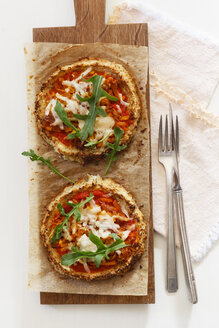 Zwei hausgemachte glutenfreie Mini-Pizzen mit Blumenkohl, Kürbis und Rucola auf Holzbrett - EVGF03077