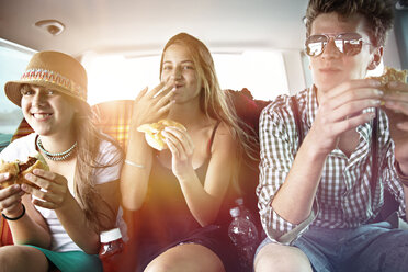 Three teenage friends having a snack in car - FSF00530