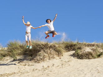 Junge und Mädchen springen von der Stranddüne - LAF01762