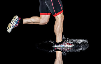 Athlete running in splashing water - STSF01098