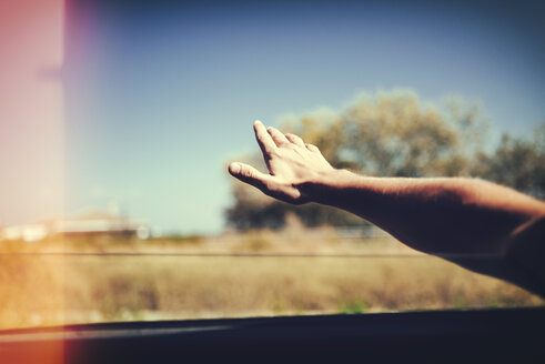 Hand eines Mannes, der sich aus dem Autofenster lehnt - KIJF00786