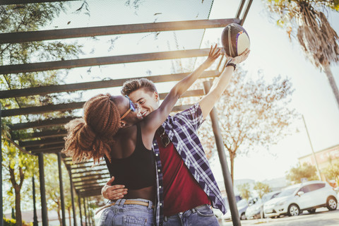 Happy young couple playing with a rugby ball stock photo