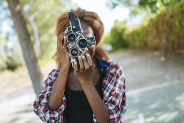 Young woman filming with an old-fashioned camera - KIJF00810