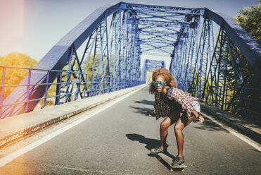 Junge Frau auf Skateboard auf einer Brücke - KIJF00818