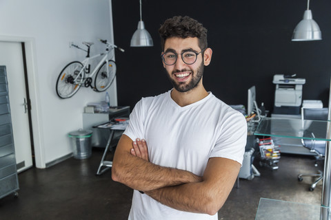 Porträt eines lächelnden Mannes mit Brille in einem modernen Büro, lizenzfreies Stockfoto