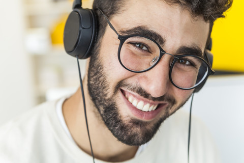 Porträt eines glücklichen Mannes mit Brille und Kopfhörern, lizenzfreies Stockfoto