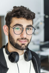 Porträt eines lächelnden Mannes mit Brille und Kopfhörern - TCF05124