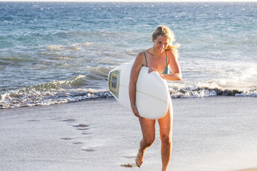 Spanien, Teneriffa, junge blonde Surferin am Strand - SIPF00875