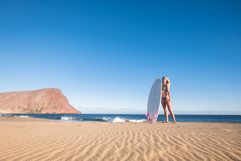 Spanien, Teneriffa, junge Surferin am Strand, lizenzfreies Stockfoto