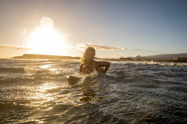 Spain, Tenerife, young female surfer at sunset - SIPF00887