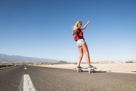 Spanien, Teneriffa, blonde junge Skaterin beim Skateboarden, lizenzfreies Stockfoto
