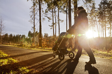 Father and son in buggy on a walk in forest - MFF03364