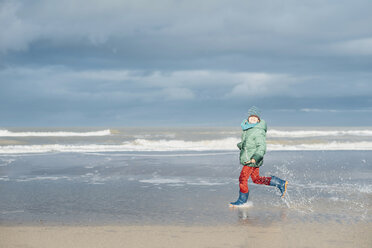 Dänemark, Skagen, Junge in Winterkleidung läuft am Strand - MJF02013