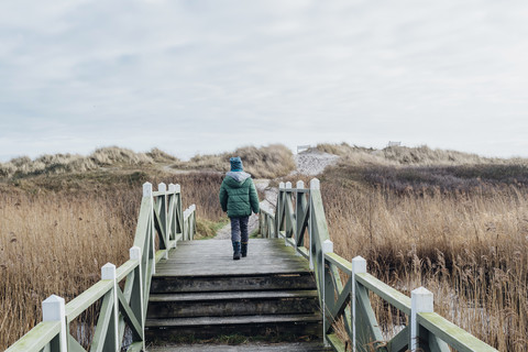 Denmark, Hals, boy in winter clothes in dunes stock photo