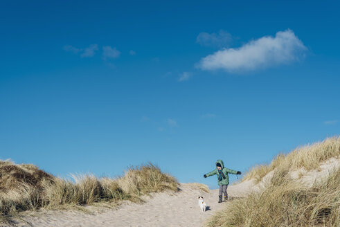 Dänemark, Bulbjerg, Junge in Winterkleidung mit Hund in Dünen - MJF02072
