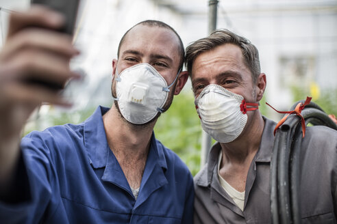 Gärtner im Gewächshaus machen Selfie mit Gesichtsmasken - ZEF10436