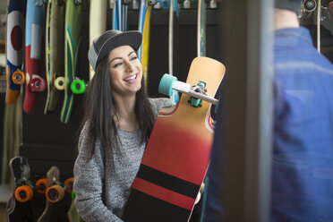 Junge Frau beim Einkaufen eines Skateboards - ZEF10443